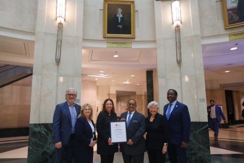 Chief Judge Munyon and Mayor Deming, along with the architects, former Chairwoman Chapin, and former Chief Judge Perry pose for a photo inside the Orange County Courthouse holding the Test of Time award.