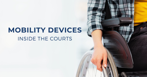 Image of a hand on a wheelchair wheel with the accompanying text: Mobility Devices Inside the Courts
